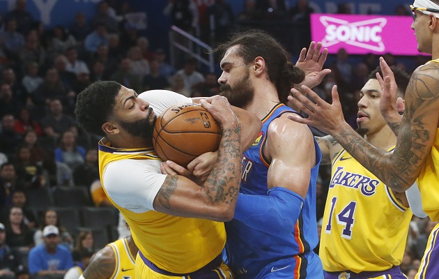 Anthony Davis (izq.) de los Lakers lucha por el balón contra Steven Adams de los Thunder. Foto:AP