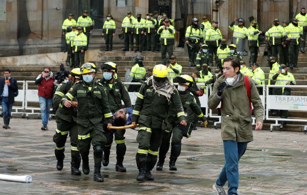 Ola de violencia y saqueos pone a Bogotá bajo un inédito toque de queda Equipos de emergencia atienden a un herido durante el cacerolazo en la Plaza Bolívar de Bogotá. Foto: EFE.