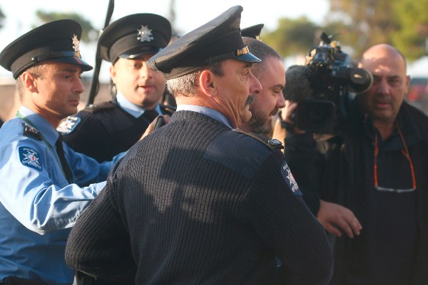 El primer ministro de Malta, Joseph Muscat, es sacado rápidamente del Parlamento, en medio de una protesta en su contra. FOTO/AP