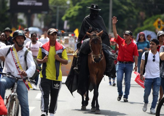 Un hombre caracterizado como el personaje 'El Zorro' participa en una marcha como parte de la tercera jornada de 