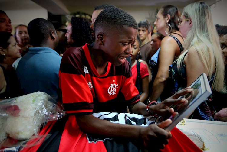 El joven Vinicius Vital llora durante el funeral de su amigo Arthur Vinicius, uno de los diez jóvenes futbolistas que perdieron la vida luego del incendio en las instalaciones deportivas del club Flamengo. Foto EFE