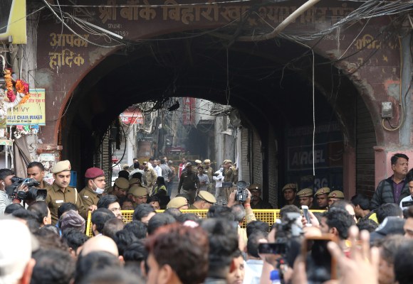 La policía y los periodistas indios se encuentran cerca del sitio donde estalló un incendio en Nueva Delhi. FOTO/AP