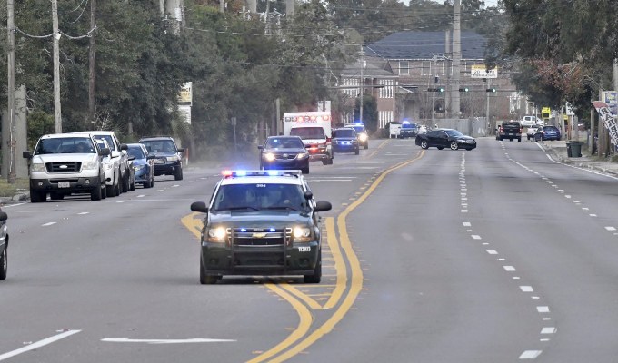 Los autos de la policía escoltan una ambulancia después de que un tirador abrió fuego dentro de la Base Aérea de Pensacola. FOTO/AP