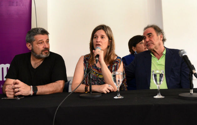 El director estadounidense Oliver Stone (derecha); la rectora de la UMET, Cecilia Cross; y el presidente del Grupo Octubre, Víctor Santa María, en el acto en Buenos Aires. Foto: EFE.