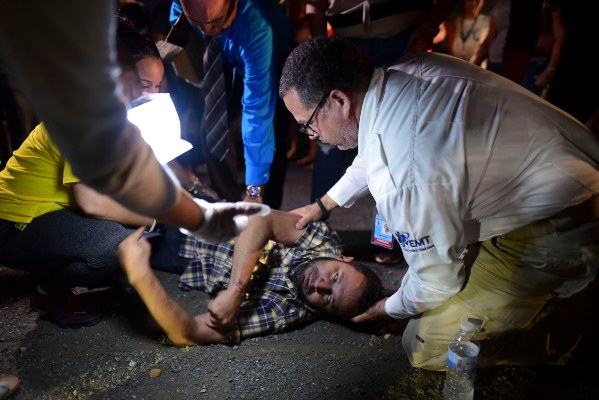 Un paramédico ayuda a un hombre después de sufrir ataques mientras él y sus vecinos permanecen afuera usando carpas de campamento y luces portátiles por temor a posibles réplicas sísmicas. FOTO/AP