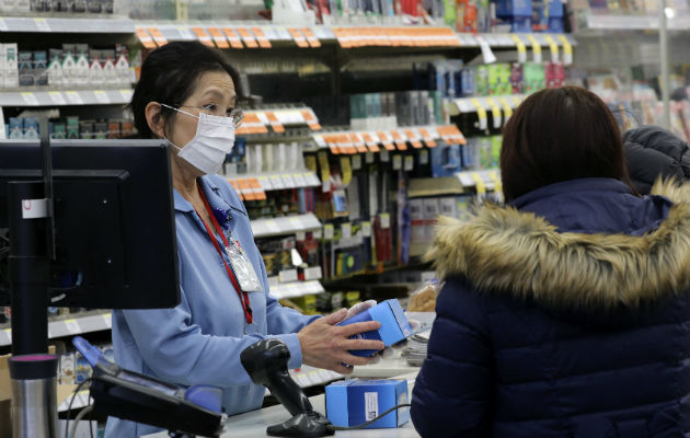 En Wuhan, la gente compra mascarillas, gafas protectoras y batas para protegerse. Foto: AP. 