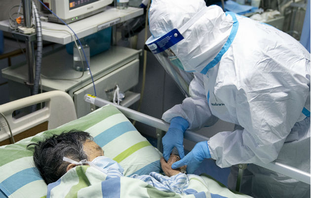 Un médico atiende a un contagiado por el virus en el hospital de la Universidad de Wuhan. Foto: AP. 