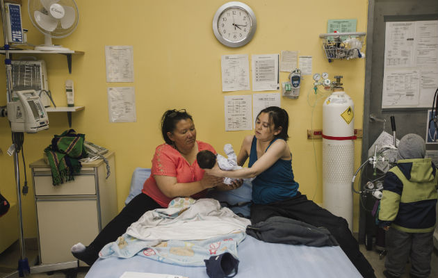 Las mujeres inuit como Susie Mina (primera izq.) ahora pueden dar a luz cerca de casa. Con su hijo y Brenda Epoo, una partera. Foto / Amber Bracken para The New York Times.