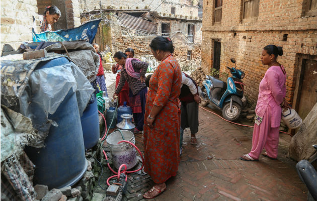 El agua de los camiones cisterna cuesta de 10 a 52 veces el agua de suministro público en 15 ciudades del mundo en desarrollo. Llenando envases. Foto / Purnima Shrestha para The New York Times.