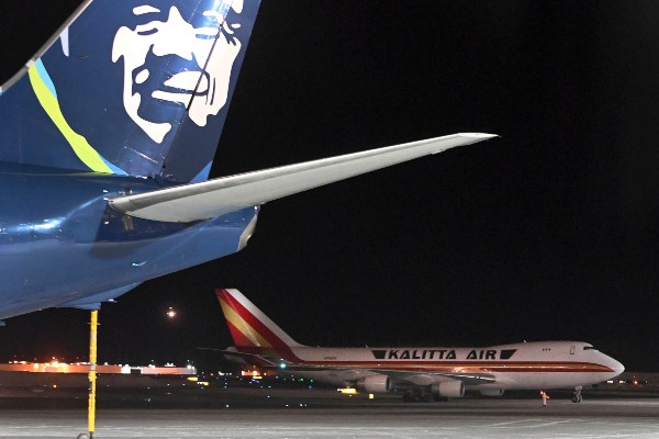 Un avión, de fondo, que transporta a ciudadanos estadounidenses que fueron evacuados de Wuhan la ciudad más afectada por el coronavirus,hace una parada de reabastecimiento de combustible en la terminal norte del Aeropuerto Internacional Ted Stevens Anchorage