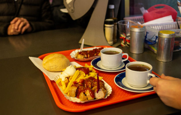 Konnopke’s se adaptó a los gustos de los alemanes occidentales en 1990. Currywurst rebanada y papas a la francesa. Foto / Lena Mucha para The New York Times.