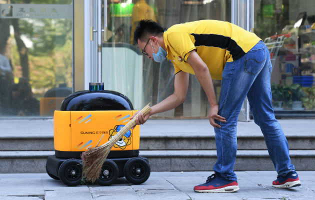 Expertos dicen que la tecnología ha evitado la recesión en China. Un robot repartidor afuera de un supermercado en Beijing. Foto / Greg Baker/Agence France-Presse — Getty Images.