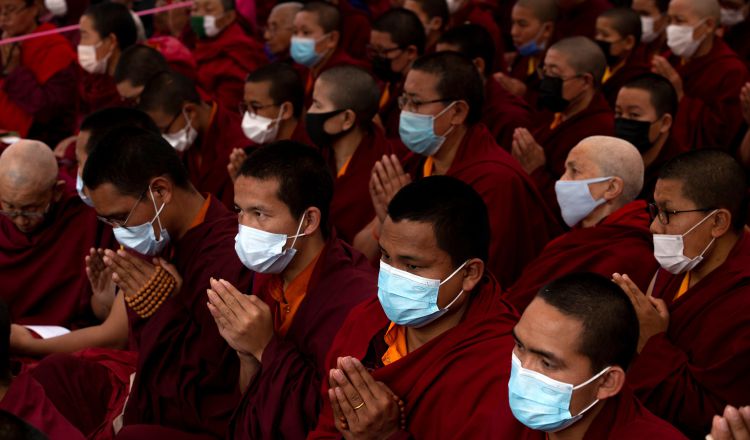 En Katmandú (Nepal), monjes budistas oran con máscaras protectoras.  EFE