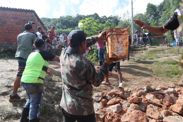 habitantes y bomberos buscando a los desaparecidos tras el derrumbe en el