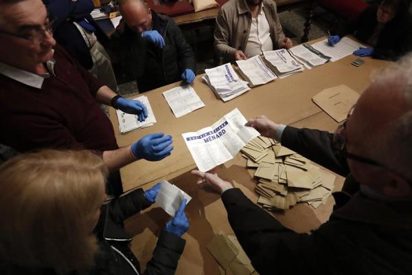 Los funcionarios que usan guantes cuentan las papeletas emitidas durante la primera vuelta de las elecciones municipales francesas en un colegio electoral, en Béziers, Francia. FOTO/EFE