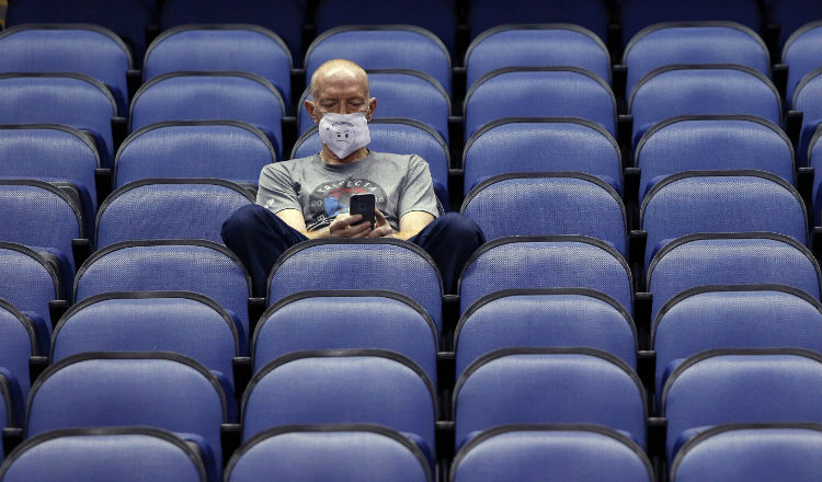 Mike Lemcke, de Richmond, Virginia, se sienta en un coliseo del baloncesto universitario de la NCAA. Foto AP