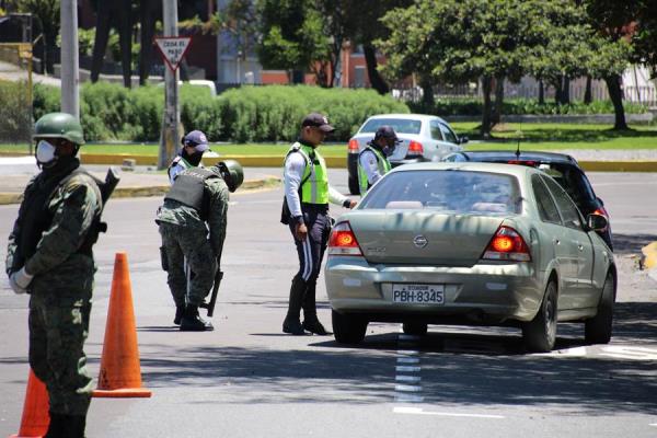 Agentes de la Policía Metropolitana de Quito y soldados del Ejército ecuatoriano controlan uno de los accesos a la ciudad para hacer cumplir las restricciones de circulación dentro del paquete de medidas para evitar la propagación del COVID-19. FOTO/EFE