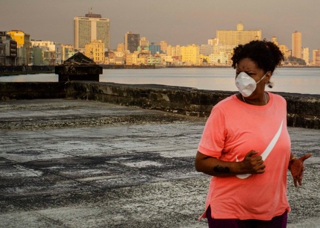 Una mujer se ejercita corriendo con mascarilla por el malecón de La Habana (Cuba). Fotos: AP.