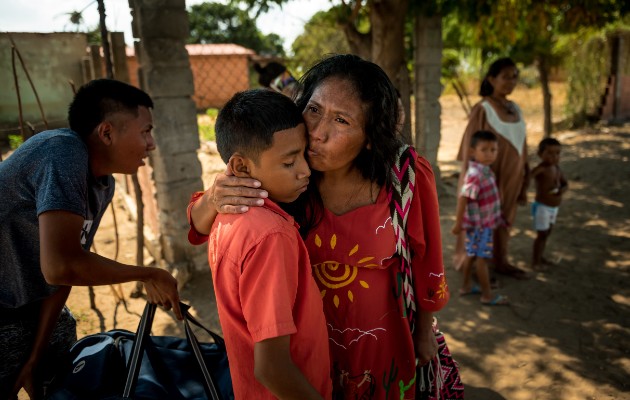 Aura Fernández besa a su hijo antes de dejar Venezuela. “Te amo”, dijo antes de irse. “Estudien mucho”. Foto / Meridith Kohut para The New York Times.