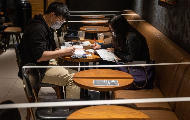 Un Starbucks en Hong Kong refuerza el distanciamiento social al no dar acceso a ciertas sillas y mesas. Foto / Jerome Favre/EPA, vía Shutterstock.