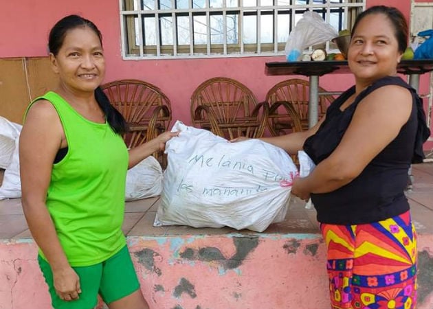 Mujeres oriundas de la comarca  Emberá-Wounaan residentes en Las Mañanitas muestran lo enviado por sus familiares. Fotos: Cortesía. 
