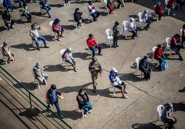 Empleados de un mercado esperan a que trabajadores del Ministerio de Salud les realicen la prueba del coronavirus. Foto / Ernesto Benavides/Agence France-Presse — Getty Images.