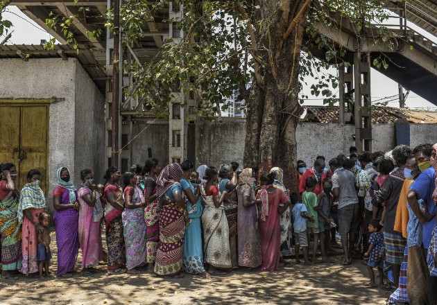 Trabajadoras migrantes hacen fila por comida en Mumbai en abril, durante el cierre de India por el coronavirus. Foto / Atul Loke para The New York Times.