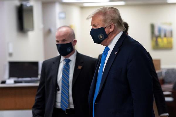 Cuando Trump fue visto este sábado con mascarilla, intentó ofrecer una imagen de fortaleza: iba rodeado de militares y miembros del servicio secreto que no se detuvieron ni un minuto ante las cámaras mientras el mandatario, al frente, dirigía el rumbo de la comitiva. FOTO/EFE