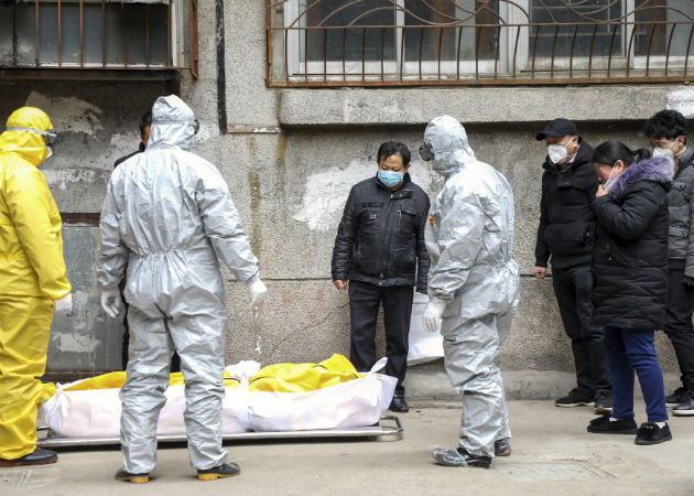 Socorristas con trajes de bioseguridad cuando retiraban un cadáver de una calle de Wuhan, China. Fotos: Archivo/Ilustrativa.