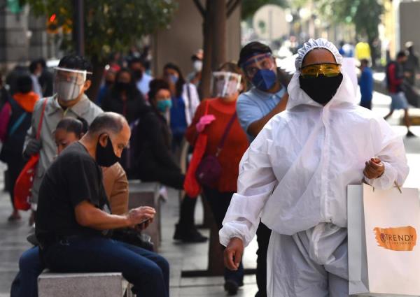 Un transeúnte viste un traje de alta seguridad sanitaria durante sus compras en el Centro histórico de Ciudad de México. 