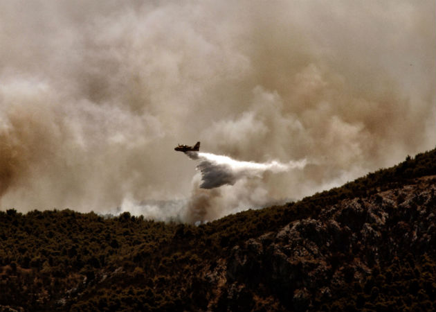 Un hombre observa su vivienda arrasada por el incendio forestal. Fotos: EFE.