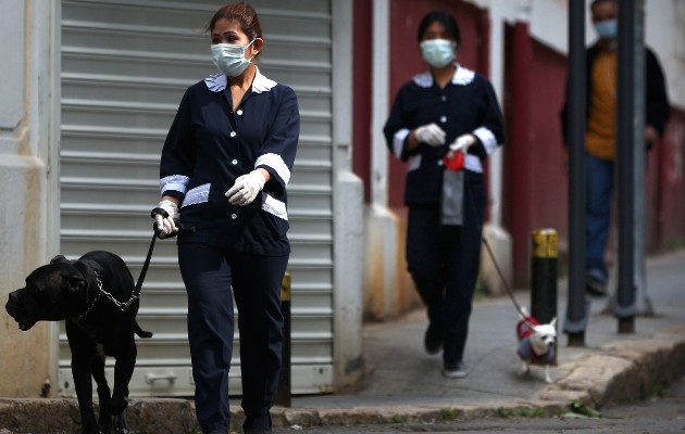 Cientos de miles de sirvientas y niñeras extranjeras laboran en países árabes. Paseadoras de perros en Beirut. Foto / Patrick Baz/Agence France-Presse — Getty Images.