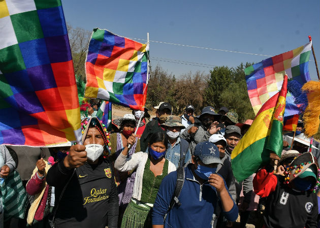 Un hombre cruza un bloqueo de una carretera durante las protestas en Cochabamba. Fotos: EFE.