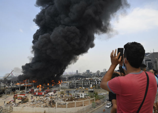 Un mes tras la explosión, un incendio en el puerto estremece de nuevo Beirut Un helicóptero de la armada lanza agua al fuego en el puerto de Beirut (Líbano). Fotos:EFE.