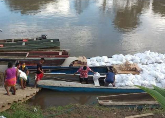 Mujeres en la comarca Emberá-Wounaan apoyan en la entrega de bolsas solidarias Las Werârâ (mujeres) de Unión Chocó descargando las bolsas de la piragua. Fotos: Cortesía.