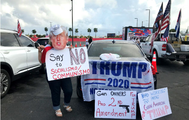Unas personas apoyan al presidente Donald Trump en una manifestación multitudinaria contra el comunismo en Miami, Florida. Foto: EFE.