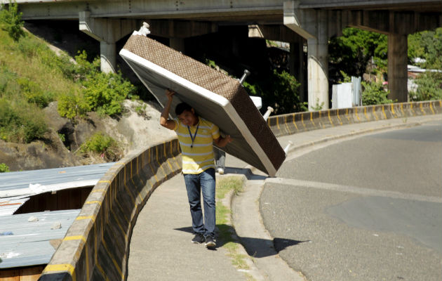 Un residente de la colonia La Betania, reubicaba ayer sus pertenencias ante el eventual desborde del río Choluteca en Tegucigalpa. Foto: EFE. 