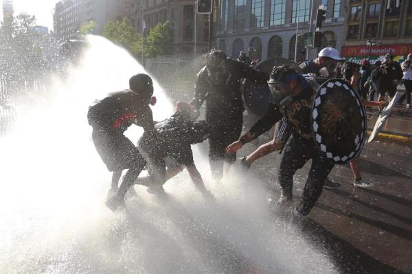 Manifestantes enfrentan a los carabineros durante una nueva jornada de protestas antigubernamentales. EFE
