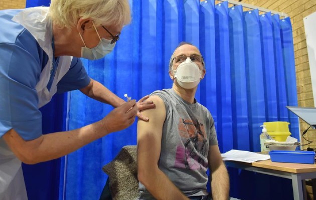 David Farrell, paciente de 51 años, recibe una de las dos vacunas de Pfizer y BioNtech en un centro de vacunación en Cardiff (Reino Unido). EFE/Ben Birchal