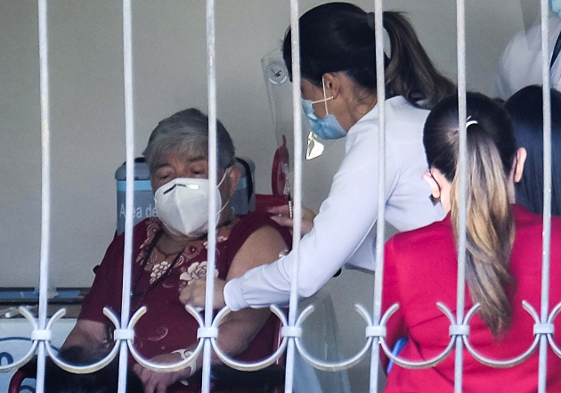 Personal del ministerio de Salud atiende a Elizabeth Castillo, quien fue la primera persona en ser vacunada contra la COVID-19 en Costa Rica, el 24 de diciembre. Foto: EFE