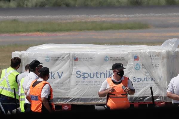 Operarios descargan contenedores de la vacuna rusa Sputnik V contra la COVID-19. EFE