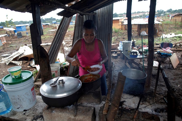 Yeisi Rodríguez, de 47 años, cocina en una casa improvisada en el terreno "Victoriano Lorenzo". Foto: EFE