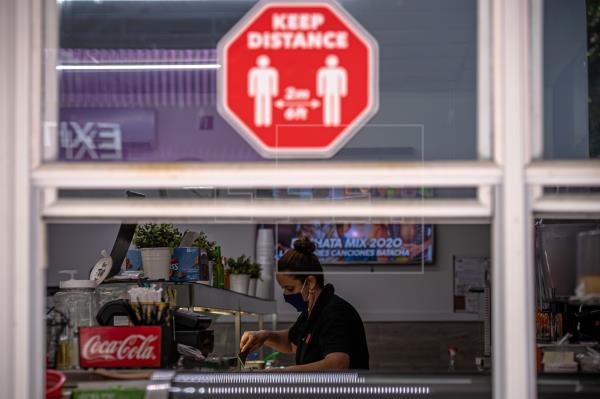 Una mujer trabaja en un local de comida que solo sirve por ventana, debido a la pandemia del coronavirus, en Miami, Florida. Foto: EFE
