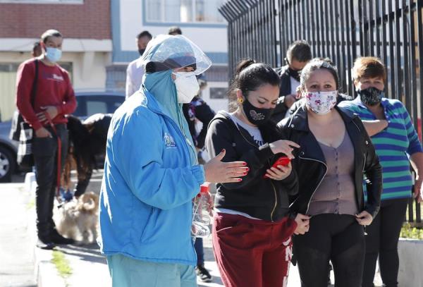 Personal médico organiza una fila de personas que se van tomar pruebas de covid-19