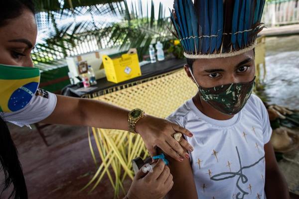 Una trabajadora del Distrito Sanitario Especial Indígena (DSEI) de Manaos vacuna a la indígena Ruan Viana, de 18 años. EFE