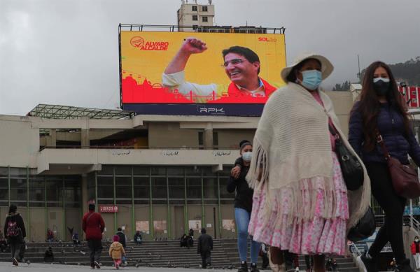 Varias personas frente a una pantalla gigante de publicidad electoral, el jueves 4 de febrero de 2021, en La Paz