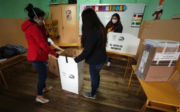 Jurados electorales instalan un puesto de votación hoy en un centro electoral en Quito