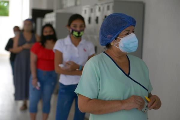 Mujeres esperan en fila para votar hoy, en un centro electoral en Guayaquil 