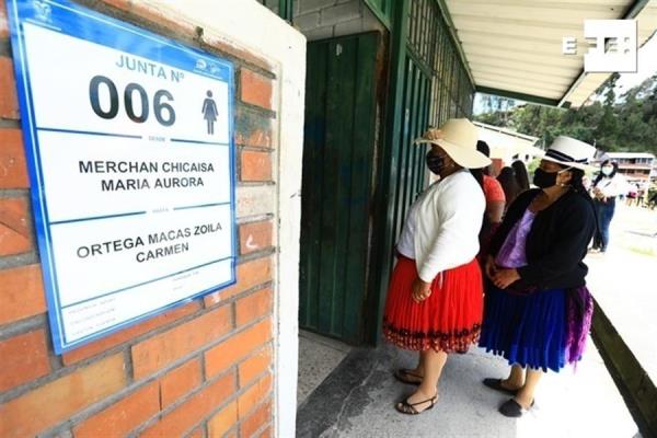Varias personas esperan para votar en las elecciones generales en Cuenta (Ecuador).