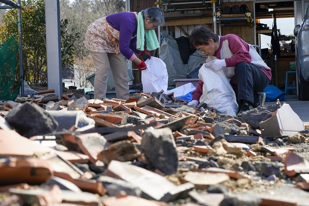 Residentes recogen tejas dañadas que se rompieron por un poderoso terremoto de magnitud 7,3 en Soma, Prefectura de Fukushima, al norte de Japón. Foto: EFE